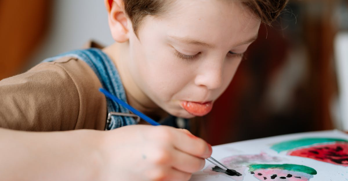 A focused child painting with a brush in an art class