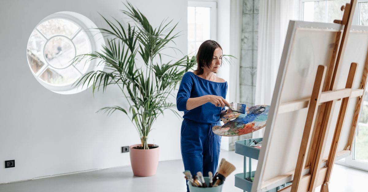 An artist working on a canvas in a studio