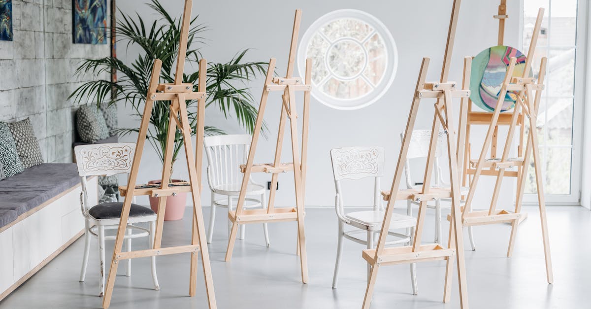 A sunlit art studio with wooden easels and chairs