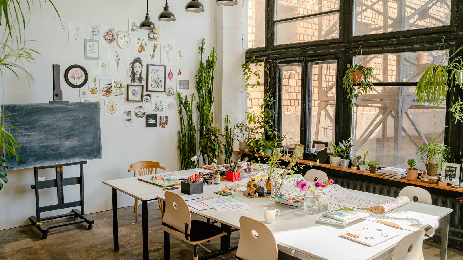 A bright art studio with worktables and supplies